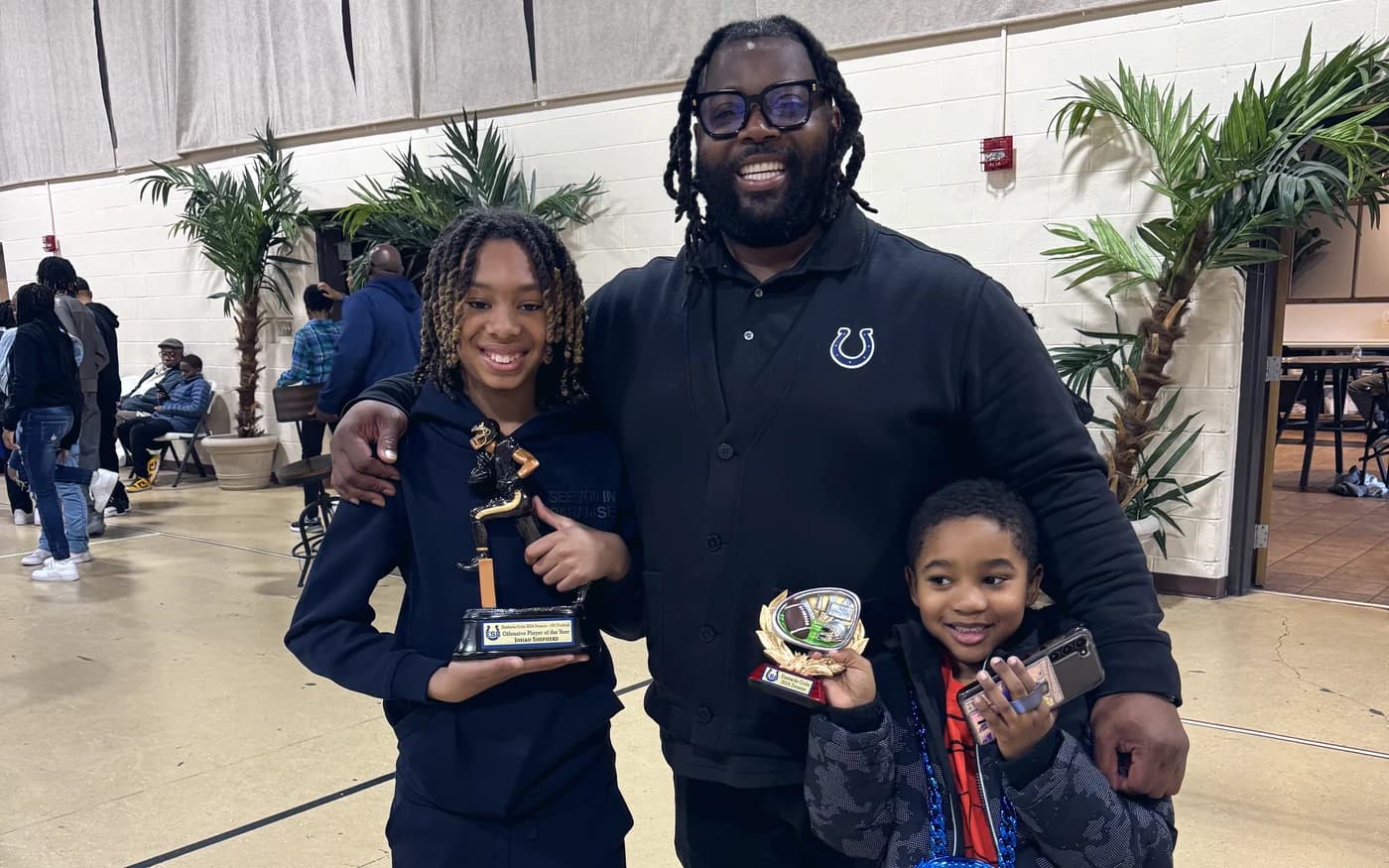 Bobby Christian with two young students holding trophies