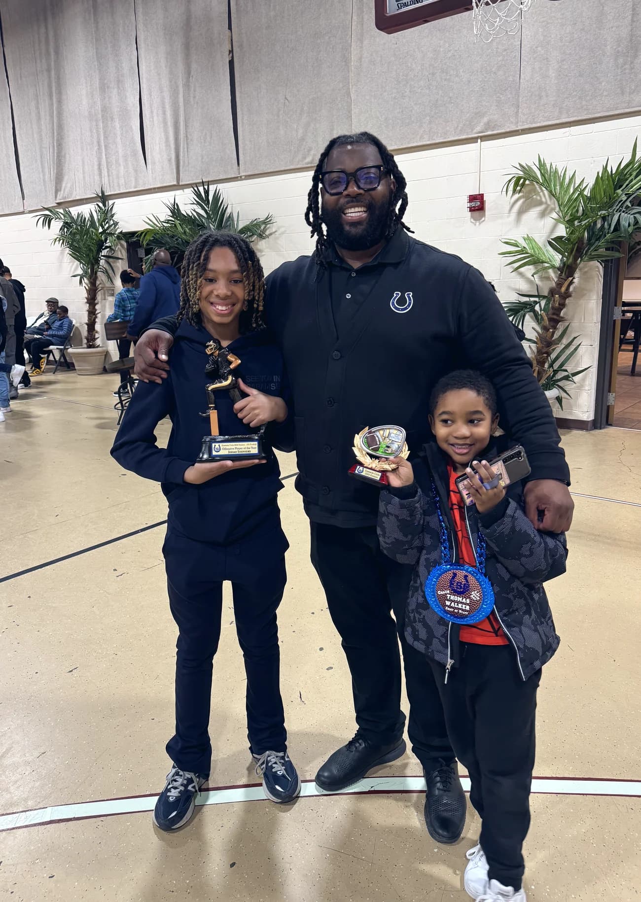 Bobby Christian with two young students holding trophies