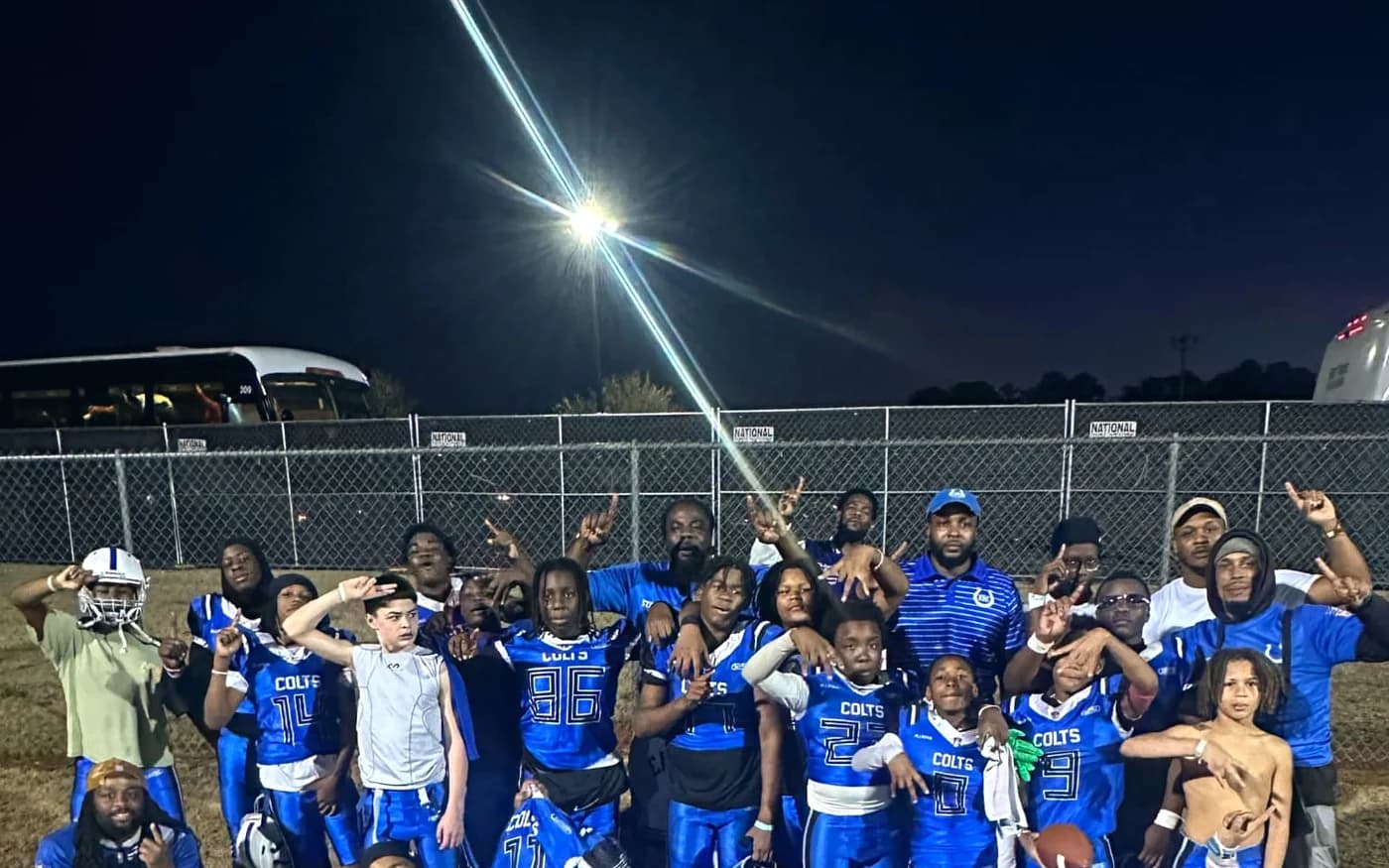 The Eastside Colts team gathered on the field under floodlights