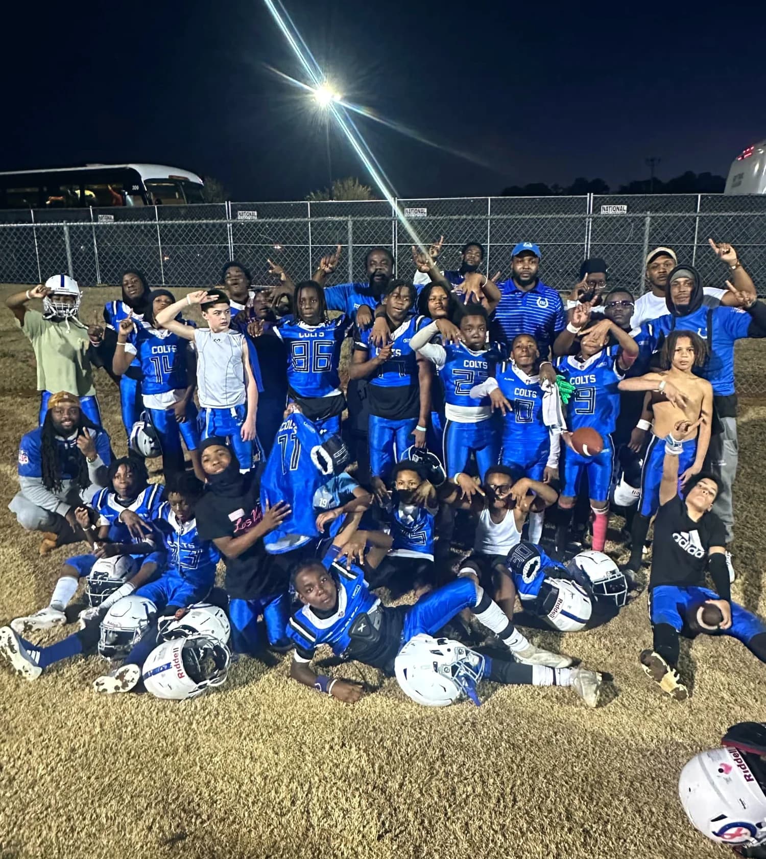 The Eastside Colts team gathered on the field under floodlights