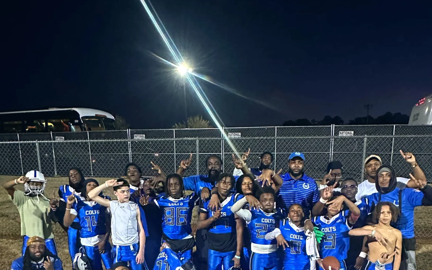 The Eastside Colts team gathered on the field under floodlights